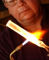 a scientific glassblower working on a piece of quartz apparatus